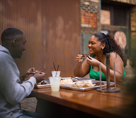black couple smiling at each other on a bbq date