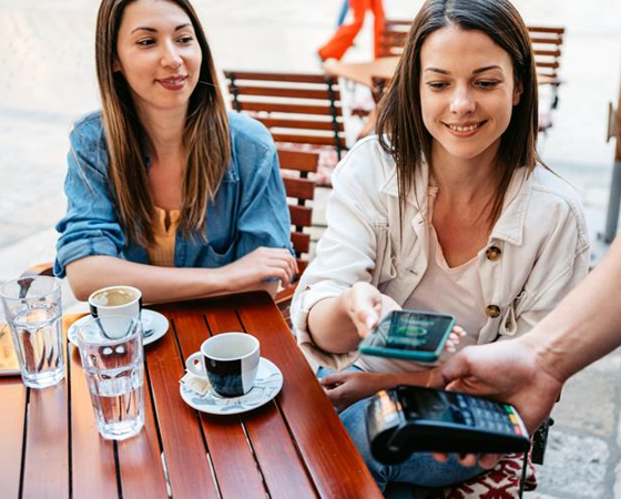Woman paying with Simplicity Checking tap-to-pay at a cafe.